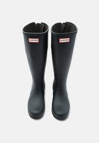 Ζεύγος μαύρων αδιάβροχων μπότες Hunter μέχρι το γόνατο με κόκκινο και λευκό λογότυπο μπροστά, φωτογραφημένες από πάνω σε λευκό φόντο.