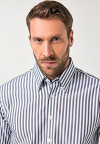 Camisa de botones a rayas con líneas verticales en azul marino y blanco, cuello estándar y tejido suave con una silueta ajustada.