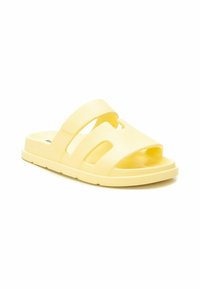 Sandalias amarillas tipo zuecos de goma, con dos correas anchas con cortes y una plantilla contorneada para mayor comodidad. Suela texturizada para un buen agarre.