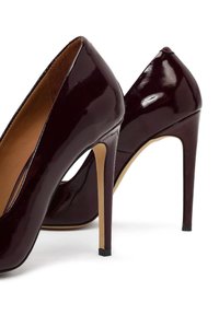 Bordowe lakierowane szpilki z ostrym noskiem, smukłym obcasem typu stiletto oraz gładką, śliską fakturą. Akcentowane złotym wnętrzem.