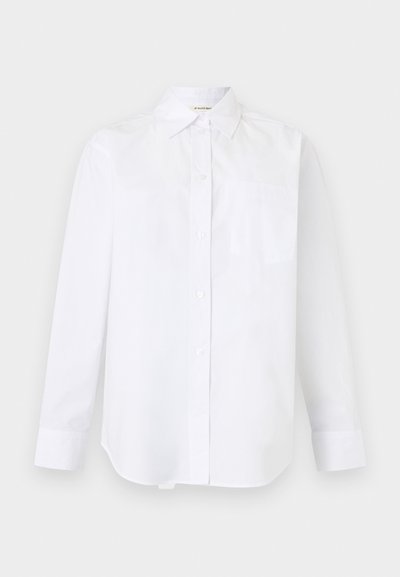 Chemise blanche à manches longues avec boutons, col pointu et une seule poche poitrine, présentée sur un fond uni.