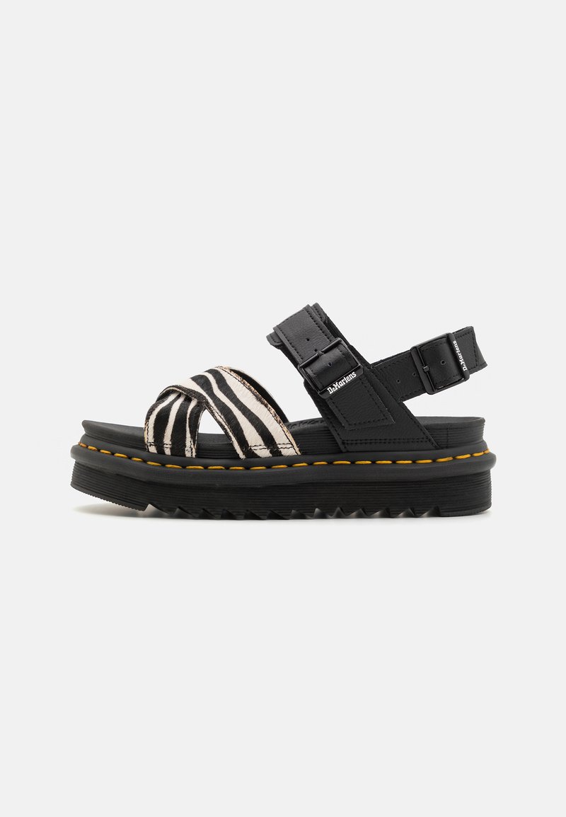 Plattformsandalen mit schwarzem Fußbett, zebra-streifen Textilriemen, verstellbaren Schnallen und kontrastierendem gelben Nähten auf einer strukturierten Sohle.