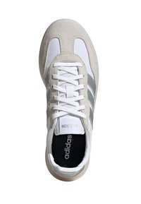 B baskets Adidas avec une tige blanche et gris clair en suède et maille, des lacets blancs et trois bandes grises sur les côtés.