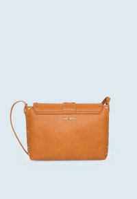 Borsa a tracolla sintetica color cuoio con chiusura a patta, borchie metalliche lungo i bordi e tracolla staccabile. Logo visibile sul davanti.