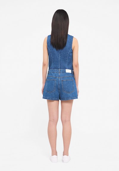 Denim jumpsuit with sleeveless design, blue color, fitted bodice, and shorts. Includes back pockets and a small brand label on waistband.