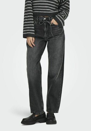 Jeans in denim nero a vita alta con una vestibilità rilassata, dotati di chiusura a bottoni, tasche frontali e una delicata texture sbiadita. Abbinati a mocassini neri.