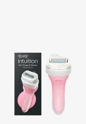 Roze en witte Wilkinson Sword Intuition 2-in-1 zeep- en scheermes met scheerschuim op het mes, naast de zwarte verpakking.