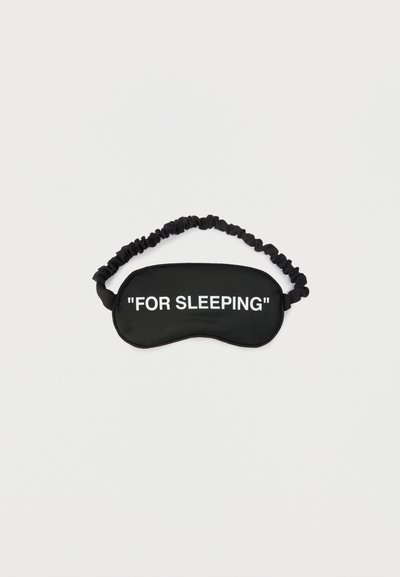 Μαύρη μάσκα ύπνου με ραμμένο ελαστικό λουράκι και λευκό κείμενο που λέει «ΓΙΑ ΥΠΝΟ» στο μπροστινό μέρος, τοποθετημένη σε λευκό φόντο.