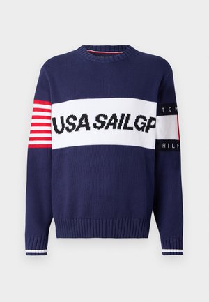 Navy knit sweater featuring "USA SAILGP" text, red and white striped accents on the sleeve, and ribbed cuffs and hem.