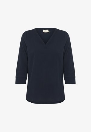 Tamsiai mėlyna V-žalias viršus pagamintas iš minkštos medžiagos, turintis trijų ketvirčių rankoves su tekstūriniu detalizavimu ant rankogalių ir apvaliu kraštu.