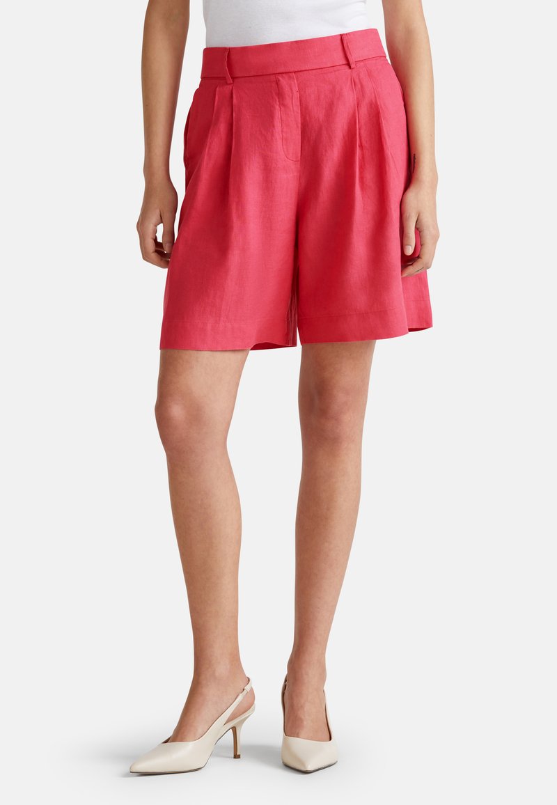 Shorts en lin rose avec des plis, taille haute et poches latérales. Associés à des talons slingback crème, avec des bouts pointus et des talons fins.