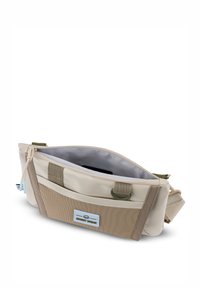 Borsa beige con fondo testurizzato marrone, chiusura a zip e tracolla verde. L'interno presenta una fodera grigia. L'etichetta esterna ha un logo blu e bianco.