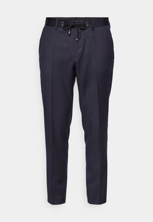 Tumši zili bikses, kas izgatavotas no gludas auduma, ar sašujamu jostu un sašaurinātu dizainu. Plakanas priekšpuses ar minimāliem detalēm, nodrošinot elegantu siluetu.