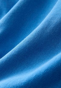 Blauwe stof met een gladde textuur en een lichte glans. Het materiaal lijkt zacht en lichtgewicht, met een consistent breipatroon.