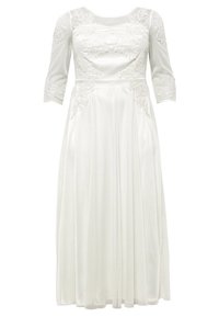 Vit klänning med trekvarts spetsärmar, blommig broderi på bystens och sidorna, flödande kjol med subtil glans och två sidofickor.