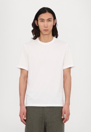 White cotton t-shirt with short sleeves, round neckline, and small logo detail on the chest. Simple and plain design with no patterns.
