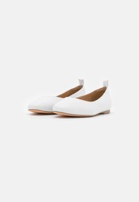 White ballet flats with a smooth leather finish, pointed toe, and minimalistic design. Features a low heel and a tab at the back.