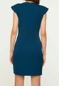 Tyrkysové krátké šaty s krátkými rukávy, přiléhavým střihem, zapínáním na zip na zádech a hladkým, strukturovaným materiálem. Minimalistický design bez vzorů.
