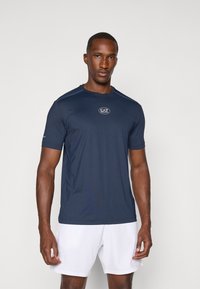 Ναυτικό μπλε αθλητικό T-shirt κοντομάνικο, κατασκευασμένο από ύφασμα που απομακρύνει την υγρασία, με μικρό λογότυπο EA7 στο στήθος και στρογγυλή λαιμόκοψη.