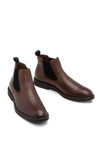 Botine Chelsea din piele maro, cu panouri elastice pe laterale, finisaj texturat, vârf rotunjit, cârlige pentru tragere și accente contrastante negre.