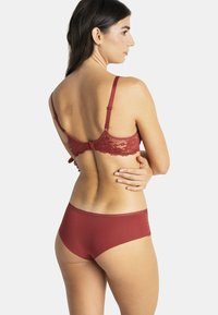 Bralette en dentelle bordeaux dans le dos et culotte taille haute assortie. Tissu doux avec des finitions en dentelle et des bretelles réglables.