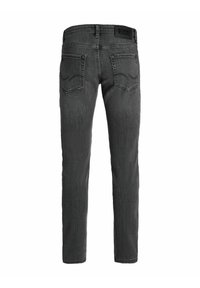 Jeans grigio scuro a taglio slim, con una leggera sfumatura, tasche posteriori con dettagli di cucitura e un'etichetta con il marchio sulla cintura.