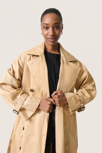 Beige trenchcoat med dobbeltknap-Design, bred krave og knapdetaljer. Fremstillet af et struktureret materiale med justerbare ærmer.