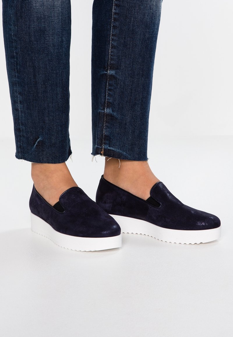 Navy modré semišové slip-on boty s elastickými bočními panely, s tlustou bílou platformovou podešví a zaobleným designem špičky.