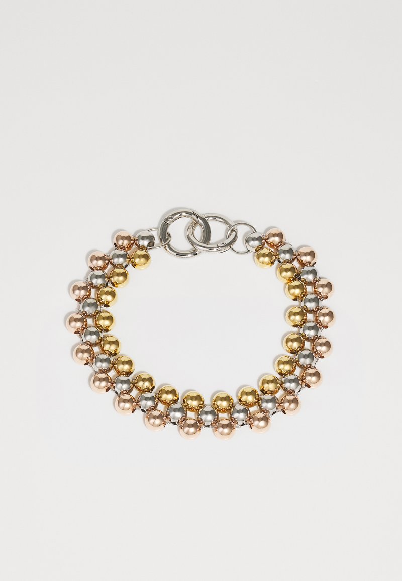 Χρυσές, ασημένιες και ροζ χρυσές σφαιρικές χάντρες συνδεδεμένες με αλυσίδα σχηματίζουν ένα βραχιόλι. Διαθέτει εναλλασσόμενα μεταλλικά χρώματα και μια ασφαλή κλειδαριά.