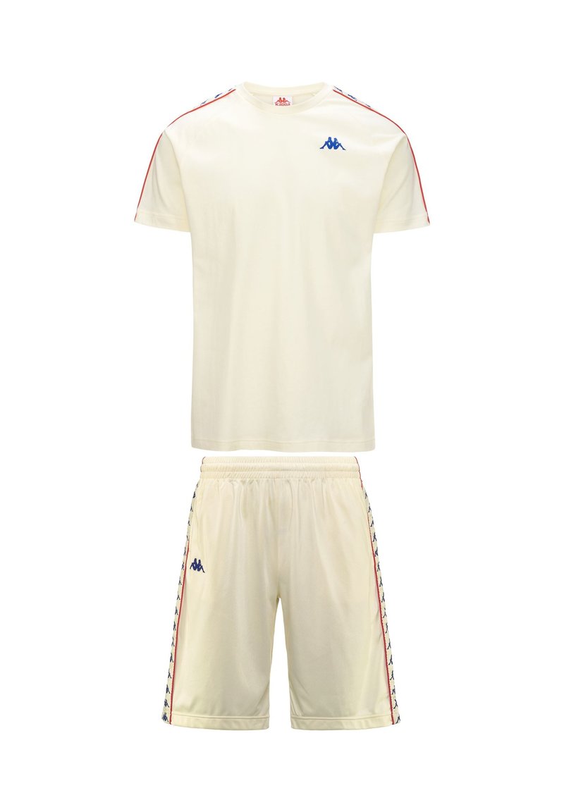 Completo sportivo color crema composto da una T-shirt a maniche corte e pantaloni shorts. Presenta un logo blu e strisce laterali rosse su entrambi i pezzi. Tessuto leggero.
