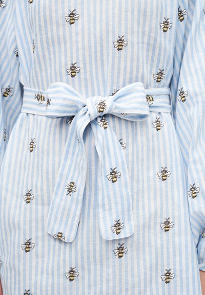Φόρεμα με ανοιχτό μπλε και λευκές ρίγες, κεντημένες μέλισσες και ζώνη με φιόγκο στη μέση.