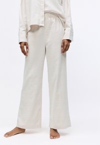 Lichtbeige wijde broek van een gestructureerde stof, met een elastische tailleband en een ontspannen pasvorm, geschikt voor casual dragen.