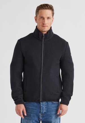 Dunkelblaue gerippte Jacke mit hohem Kragen, Vorderreißverschluss und Seitentaschen; strukturierter Stoff, taillierte Passform mit langen Ärmeln.