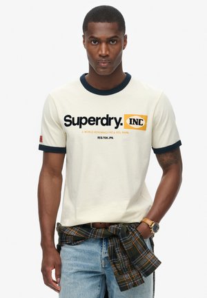Crème katoenen t-shirt met korte mouwen, voorzien van een marineblauwe ribboord bij de kraag en mouwen, met het "Superdry INC" logo in vetgedrukte zwarte en oranje tekst.