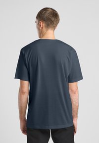 T-shirt à manches courtes bleu foncé en coupe décontractée. Il présente un col rond et une texture lisse. Design simple sans motifs ni impressions.