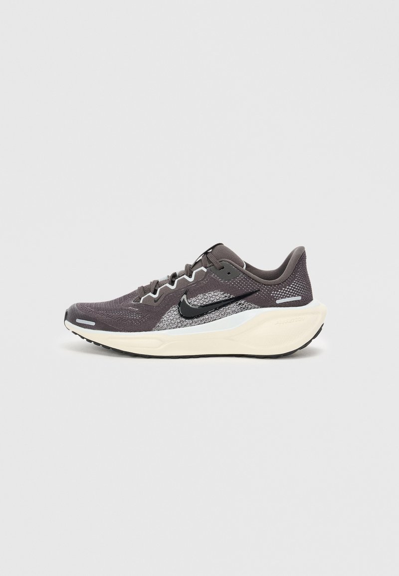 Chaussure de sport gris foncé avec une tige en mesh, des accents noirs, des détails réfléchissants et une semelle intercalaire blanche. Dotée d'une semelle extérieure en caoutchouc texturé.