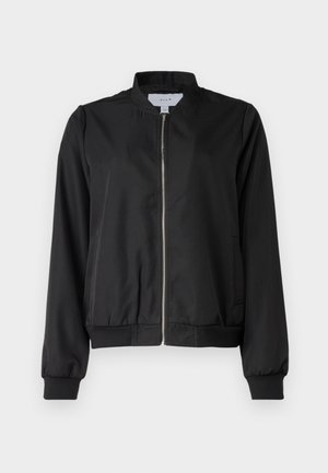 Melna bomber jaka ar rāvējslēdzēju priekšpusē, noapaļotu apkakli, elastīgām piedurknēm un jostu. Izgatavota no gludas auduma ar sānu kabatām.