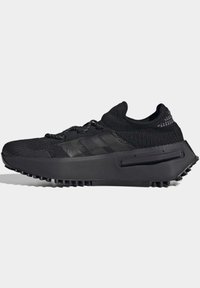 Black athletic shoe featuring a knitted upper, textured design, three stripes branding, and a rugged rubber sole for traction.