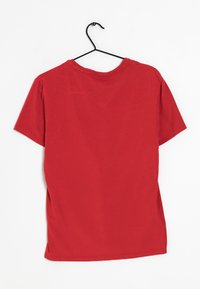 Rode kortarmige t-shirt op een zwarte hanger, gemaakt van gladde stof met een ronde hals, voorzien van zijslits en een eenvoudige uitstraling.