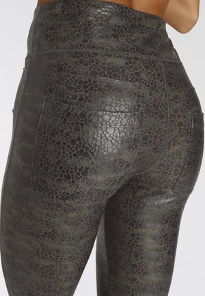 Svarta fusk läder leggings har ett texturerat mönster som liknar djurmönster, med en hög midja och bakfickor för extra detaljer.