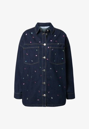 Veste en denim avec une fermeture à boutons, deux poches poitrine et des ornements en sequins colorés éparpillés sur un tissu bleu foncé.
