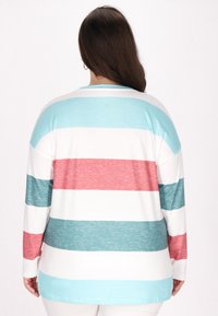 Camică cu mânecă lungă, cu dungi horizontale în nuanțe de turcoaz, coral și alb. Material moale, cu o croială relaxată și hem rotunjit.