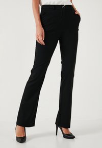 Black tailored pants with straight legs, button closure, and pockets. Made of smooth, stretchy fabric for comfort. Accented with a sleek finish.