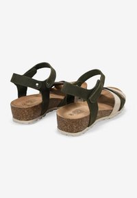 Sandalias verde oscuro con suela de corcho, que presentan dos correas ajustables, plantilla texturizada y un detalle de rayas horizontales blancas.