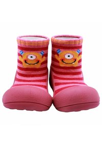 Botas infantiles rosas con suela de goma texturizada, que presentan una tela de rayas rosas y un diseño de monstruo con un ojo y sonrisas.