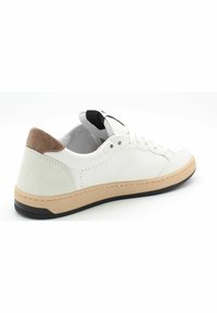 Baskets en cuir blanc avec un empiècement en daim texturé au niveau du talon, des coutures surlignées, et une semelle en caoutchouc avec un intermédiaire beige.