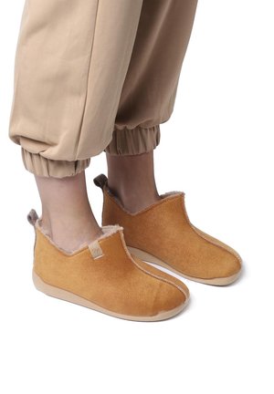 Instappers in een warme tan kleur, met een zachte suede textuur, een faux fur voering en een low-profile ontwerp met een rubberen zool.