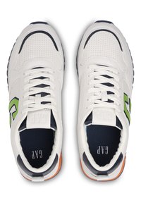 Weiße Sneaker mit perforierter Textur, marineblauen Akzenten und einem grünen Logo. Sie verfügen über flache Schnürsenkel und eine gepolsterte Innensohle mit sichtbarem Markenlabel.
