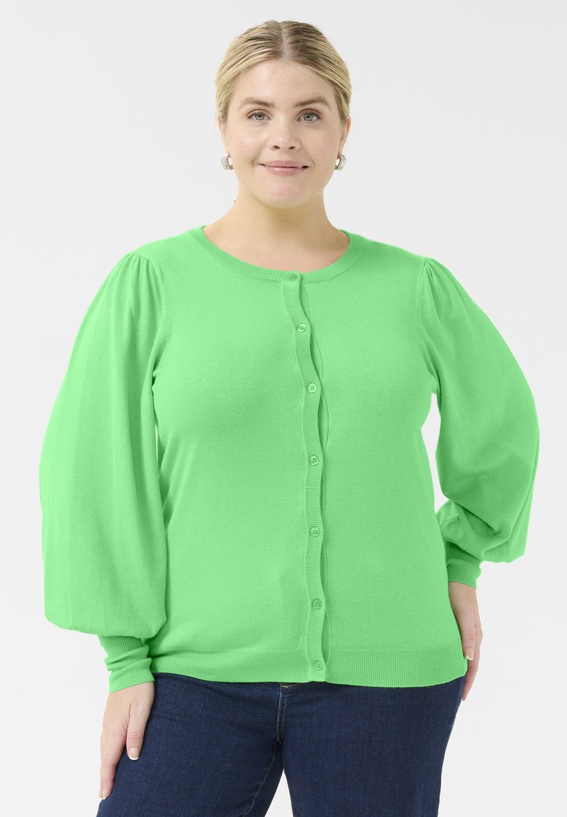 Lys grøn cardigan med rund hals, knaplukning og puffede lange ærmer. Lavet af blødt materiale med ribbede manchetter og kant.