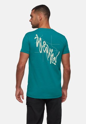 Aqua katoen t-shirt met een crème abstract ontwerp op de achterkant. Korte mouwen en een ronde hals, met een getailleerde pasvorm.